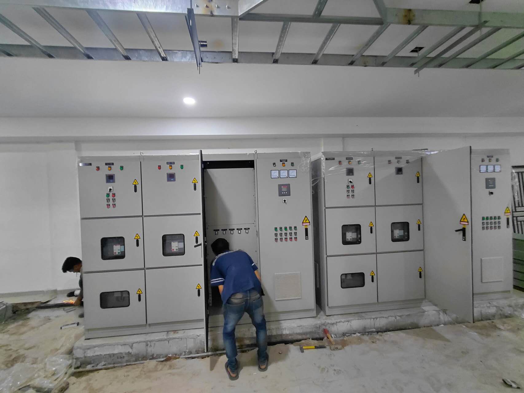 Teknisi sedang melakukan instalasi dan perataan panel distribusi elektrikal