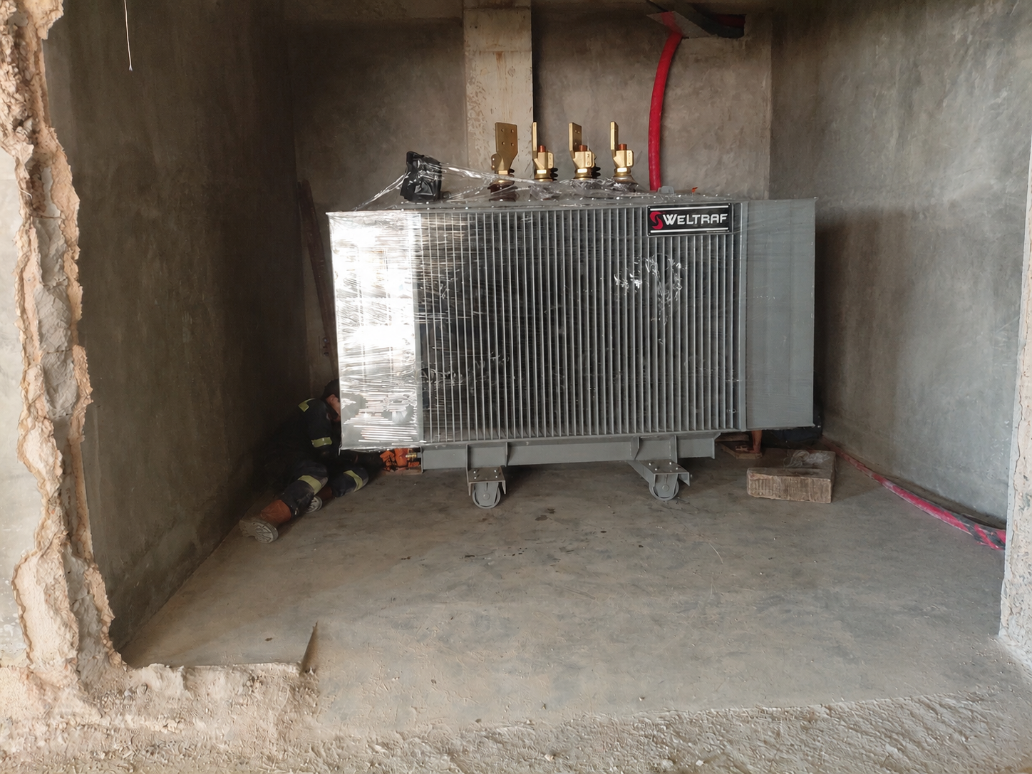 Transformer besar yang diposisikan di dalam ruang elektrikal khusus